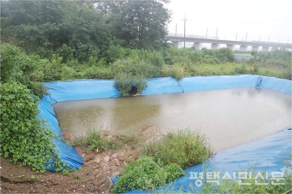 8월 31일 많은 비가 내리는 가운데 고덕신도시 내 폐기물 처리 현장에 설치된 침사지에서 침출수가 넘치고 있다.