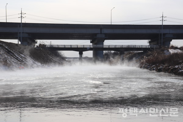 2021년 1월 삼성전자 고덕산업단지를 지나는 평택제천 고속도로 밑 서정천에 마치 온천수 같은 수증기가 자욱하게 퍼져 있다. 평택시민환경연대 등 환경단체들이 삼성전자가 조성하는 평택반도체산업단지에서 하루 발생하게 될 34만톤의 방류수 대책을 촉구하면서 배출되는 화학물질에 대한 우려를 표명하고 있다.