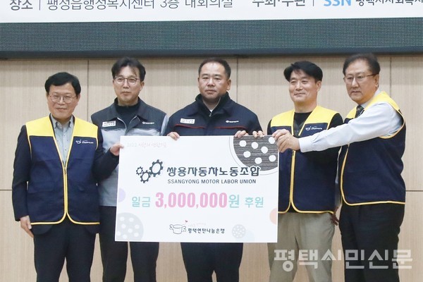 쌍용자동차 노동조합 선목래 위원장이 평택연탄나눔은행에 후원금 300만원을 전달하고 있다.(가운데가 선목래 노동조합위원장)