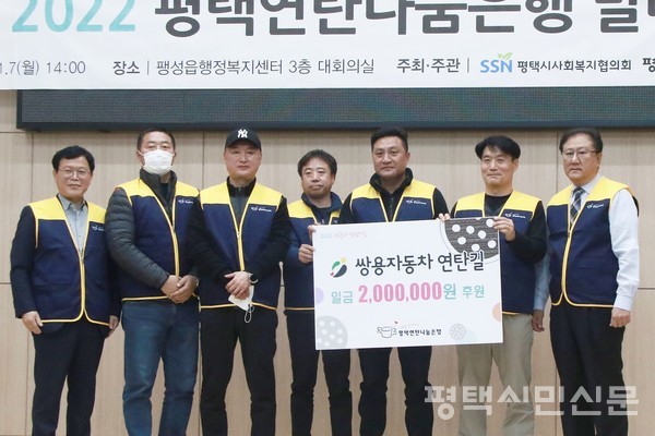 쌍용자동차 봉사단체 연탄길 회원들이 평택연탄나눔은행에 후원금 200만원을 전달하고 있다.