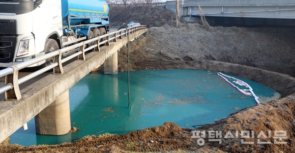 1월 12일 오성면 양교리의 하천에서 탱크로리 차량이 에틸렌다이아민 유출로 파랗게 변한 오염수를 처리하고 있다. 사진=한종수 기자