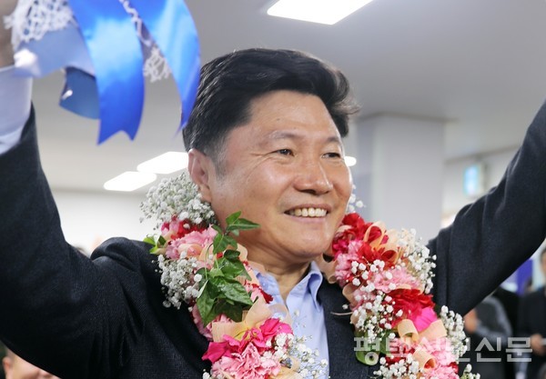 평택시갑 홍기원 당선자가 승리의 꽃다발의 목에 걸고 지지자들과 함께 당선의 기쁨을 나누고 있다.