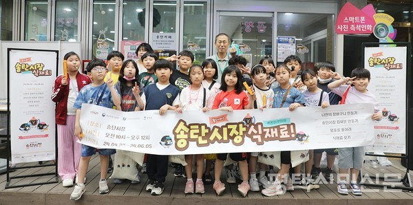 5월 23일 송탄시장에서 진행된 키즈마켓데이 체험에 참여한 송북초 3학년 학생들이 한데 모여 기념사진을 찍고 있다. 