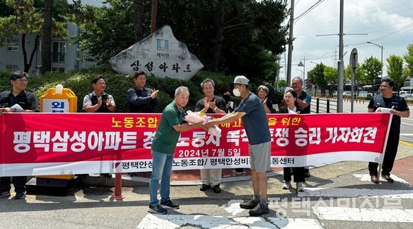 민주노총 민주일반연맹 평택안성지역노동조합이 5일 통복동 삼성아파트 앞에서 경비원 A씨에게 복직을 축하하는 꽃다발을 건네고 있다. 