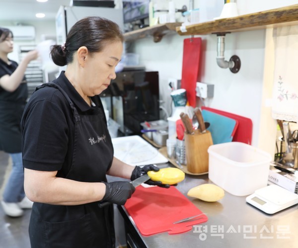 망고빙수를 만들기 위해 김미자 사장이 망고를 손질하고 있다.