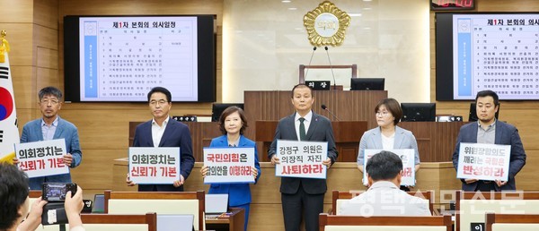 16일 열린 임시회에서 민주당 소속 의원들이 ‘강정구 의원의 의장직 자진 사퇴’, ‘국민의힘 합의안을 이행하라’ 등의 문구가 적힌 피켓을 들고 있다.