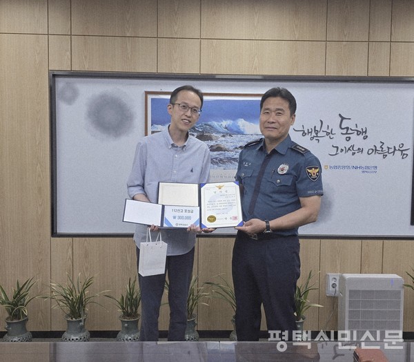 NH농협은행 평택시지부 김용민 과장(왼쪽)이 보이스피싱으로부터 고객자산을 지켜내 8월 5일 맹훈재 평택경찰서장에게 감사장을 전달받고 기념사진을 찍고 있다. 