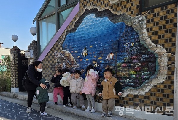 11월 21일 ‘신장2동 도시재생 성과 온(ON) 페스티벌’ 마을 투어에서 어린이집 유아들이 자신들이 제작에 참여한 타일 벽화 앞에서 기념사진을 찍고 있다.